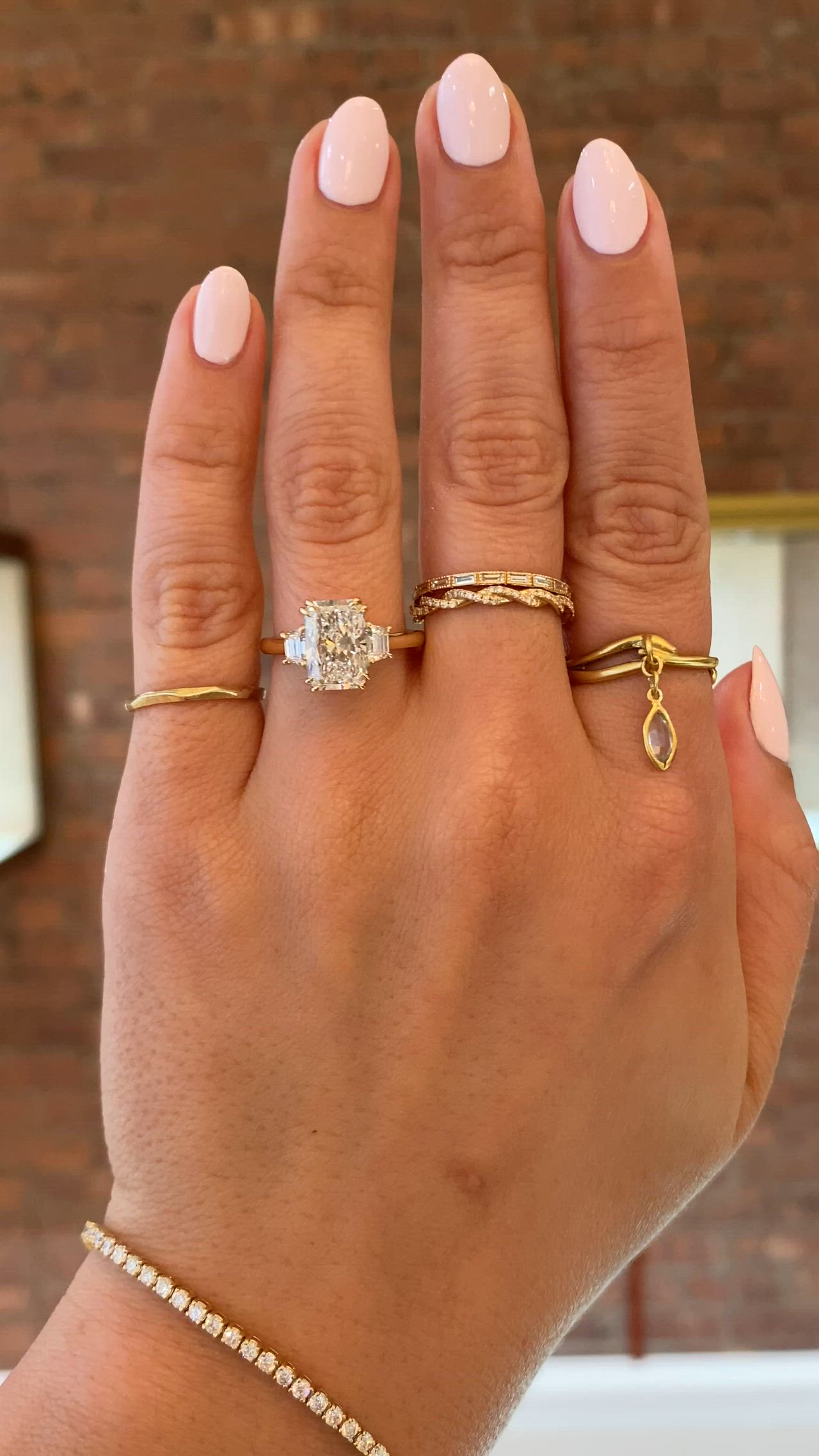 This may contain: a woman's hand with three different rings on her left and one ring on the right