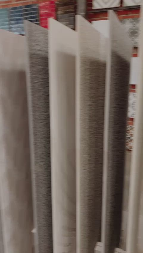 This may contain: a bunch of different shades of gray and white fabric hanging on a rack in a store