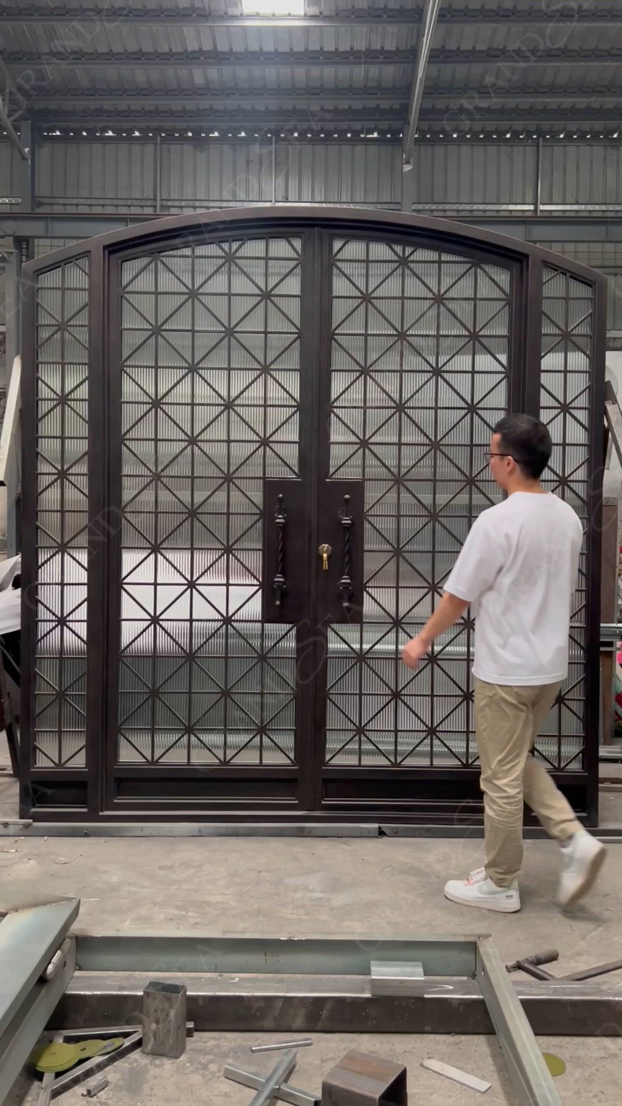 This may contain: a man walking past a metal gate in a building with lots of steel bars on it