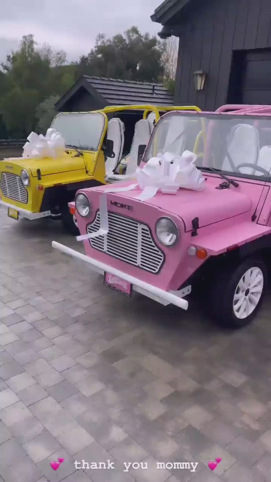 This may contain: two orange and white jeeps parked in front of a building