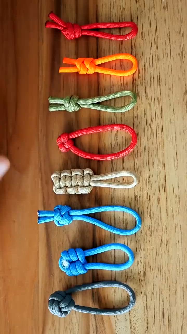 This may contain: four different colored ropes are lined up on a wooden surface, with one knot in the middle