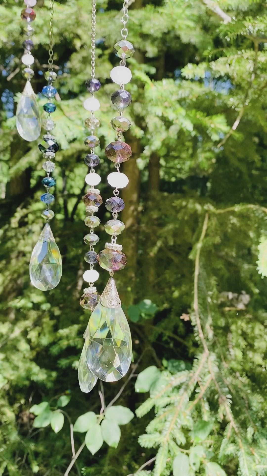 This may contain: a wind chime hanging from a tree filled with lots of beads and glass drops