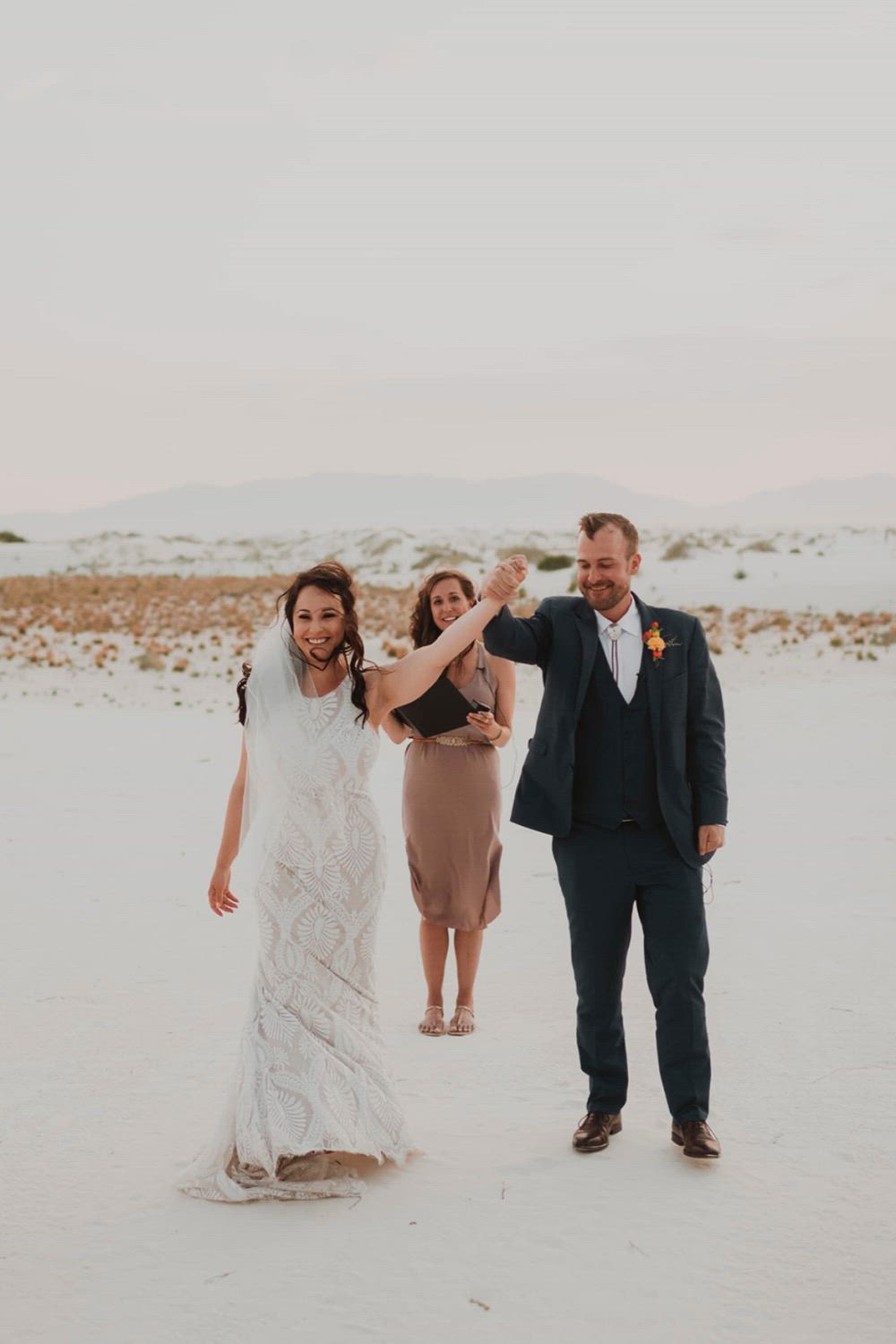 This may contain: a bride and groom walking in the snow with text that reads, wedding dresses for every bride's dream