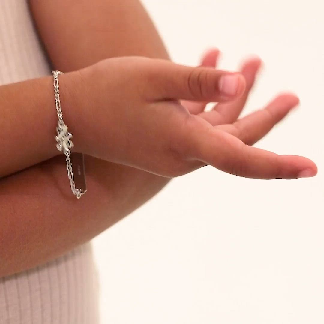 This contains: Highlighting a 5" Teddy Bear Tag ID bracelet for babies and toddlers, crafted from sterling silver and featuring a figaro style. This charming accessory, presented by In Season Jewelry, pairs safety with a dash of fun for your little ones.