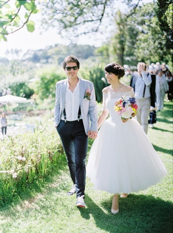 A relaxed groom's look with black pants, suspenders, a white shirt, a light blue jacket and matching sneakers