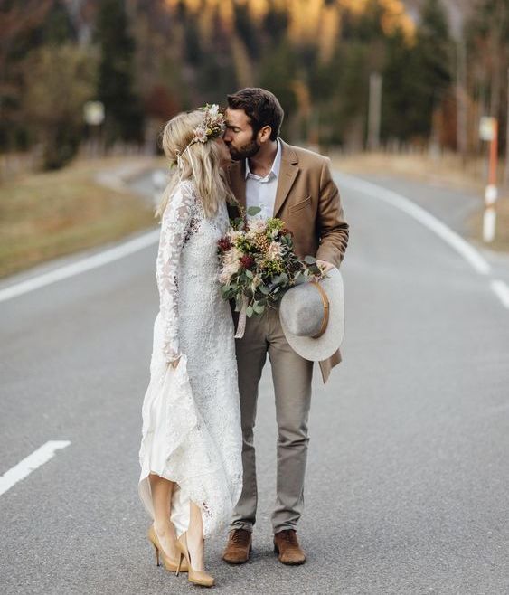 a simple look with grey pants, a white shirt, a tan jacket and boots and a grey hat that adds a boho touch