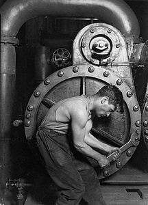 man wearing tank top and black pants holding wrench tool