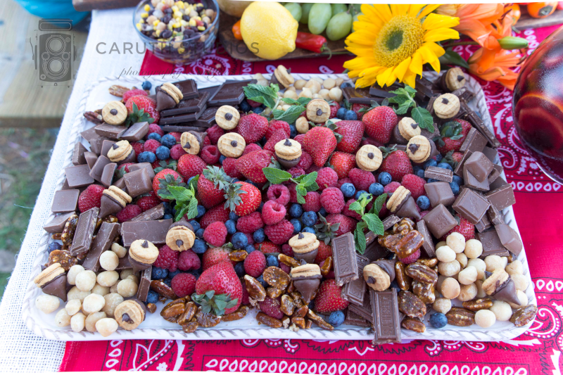 fall themed chili party dessert platter with berries, chocolate and acorn shaped chocolate kisses