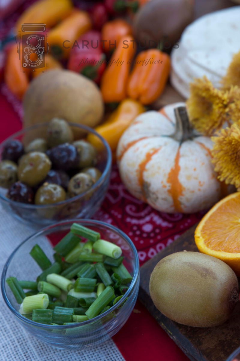 green onion and olives amongst peppers and pumpkins