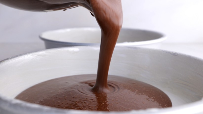 pouring batter into greased cake pans