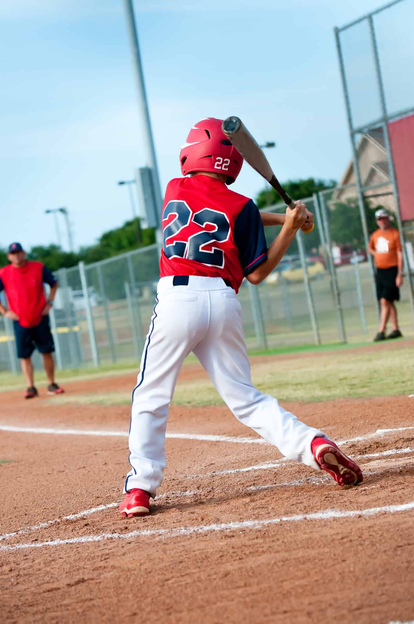 boy hitting baseball in game