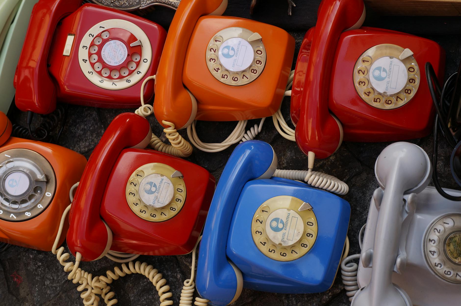 seven assorted colored rotary telephones