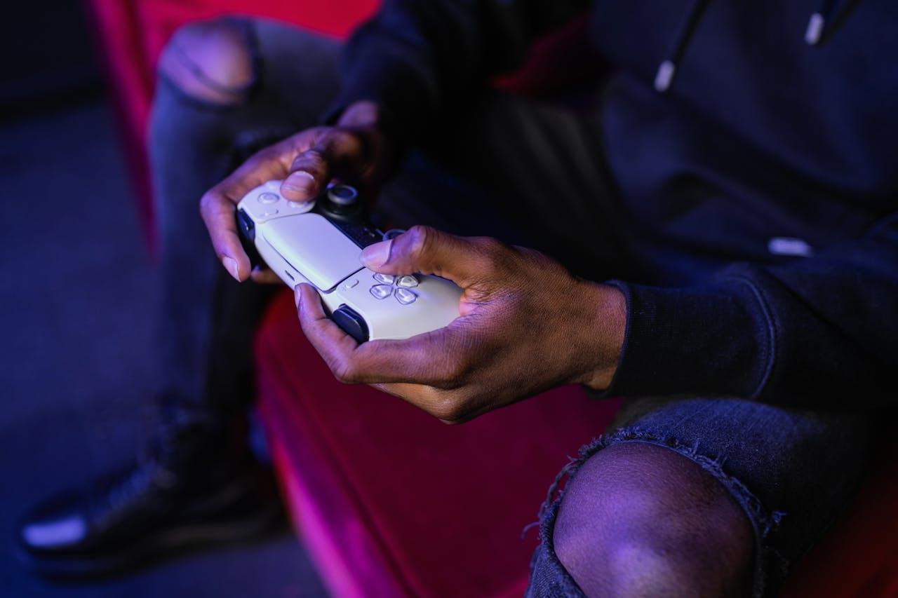 Some key industries belonging to the digital entertainment umbrella include streaming, video-on-demand, video games, and social media. (PICTURED) A man with a gaming controller. PHOTO: Alena Darmel/Pexels