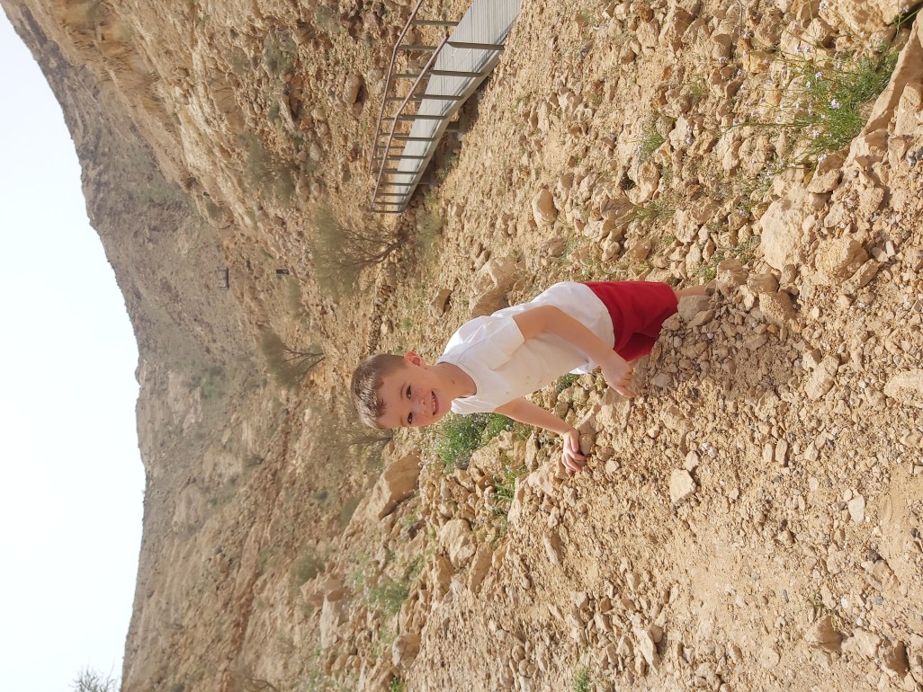 Boy climbing up rocks.