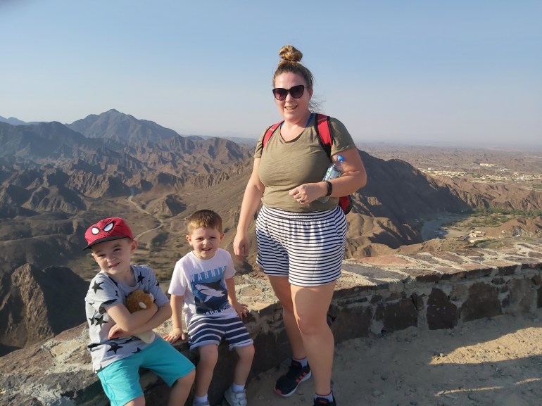 Mum and boys at top of mountain on family hike in UAE.