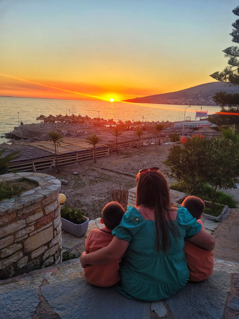 Mum and 2 boys looking at the sunset during travel to Albania. 