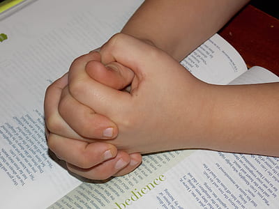 person's hand on book