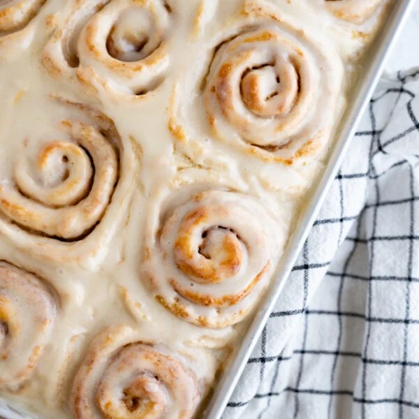 A pan of quick cinnamon rolls topped with icing.