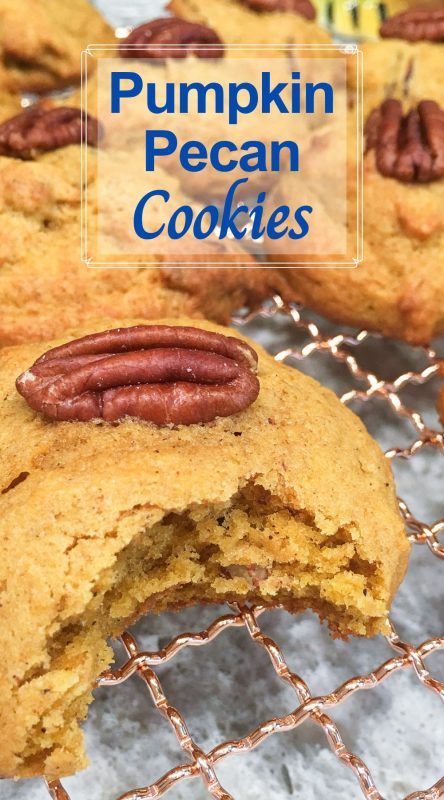 Fluffy pumpkin cookies topped with a pecan on gold cooling rack.