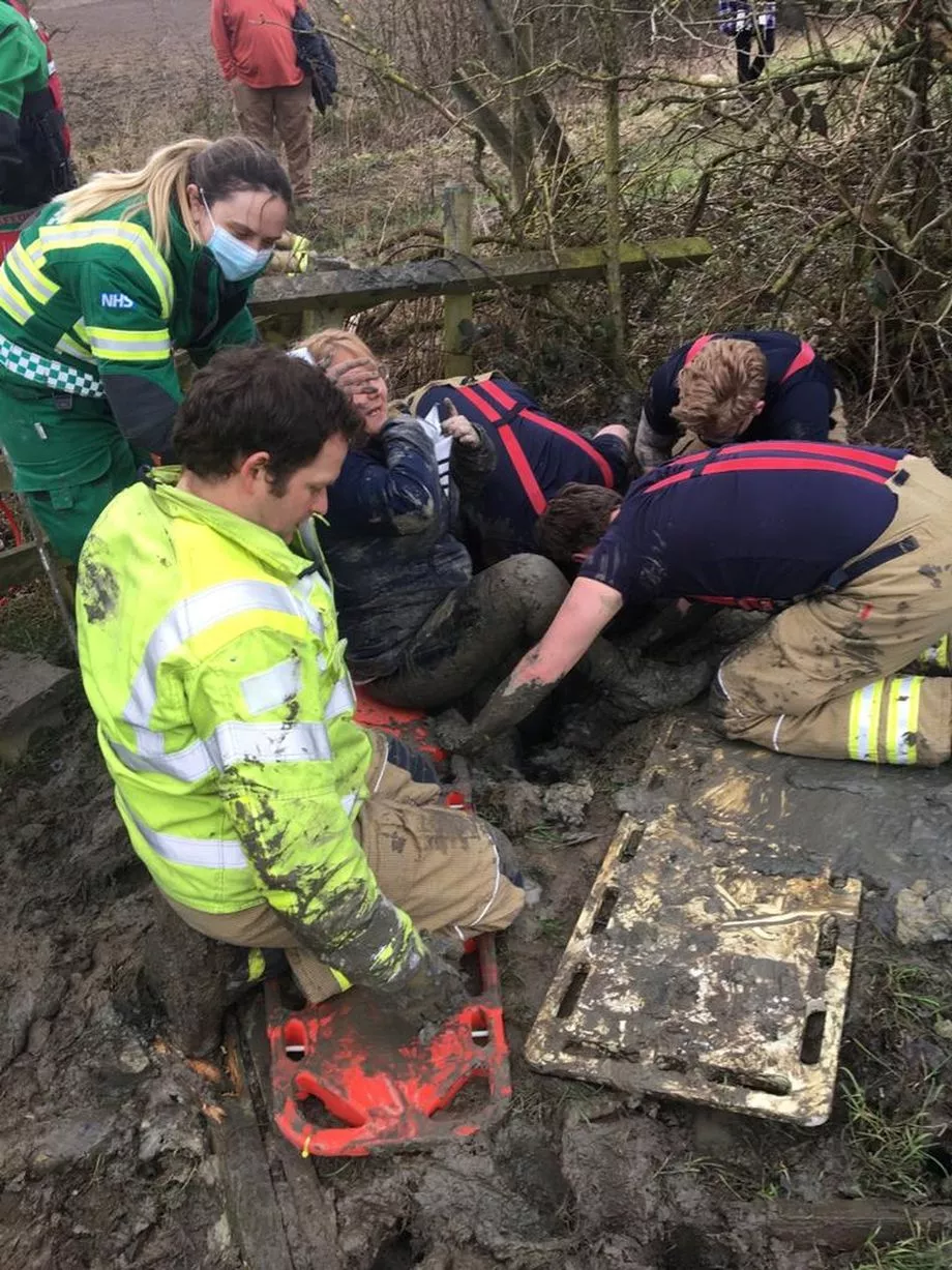 The woman is lifted to safety after getting stuck in mud