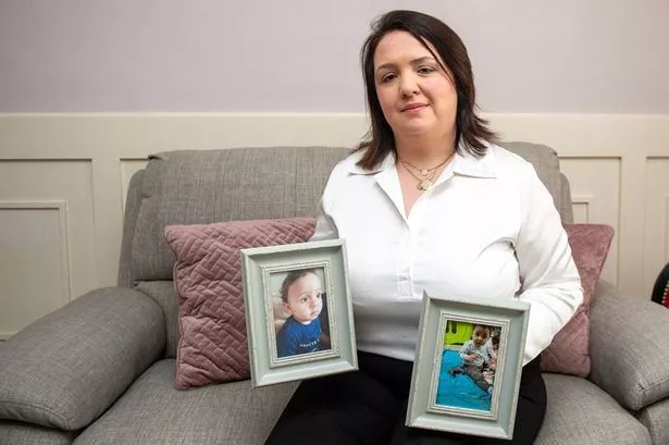 Mandy Kelly pictured at home holding pictures of Zayn and Kareem