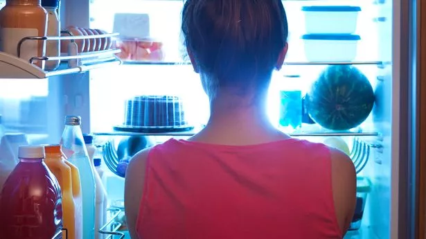 woman looking in fridge