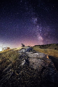 beige grass covered mountain under purple sky ay nighttime