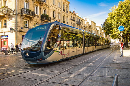 silver electric train in the middle of the street during daytime