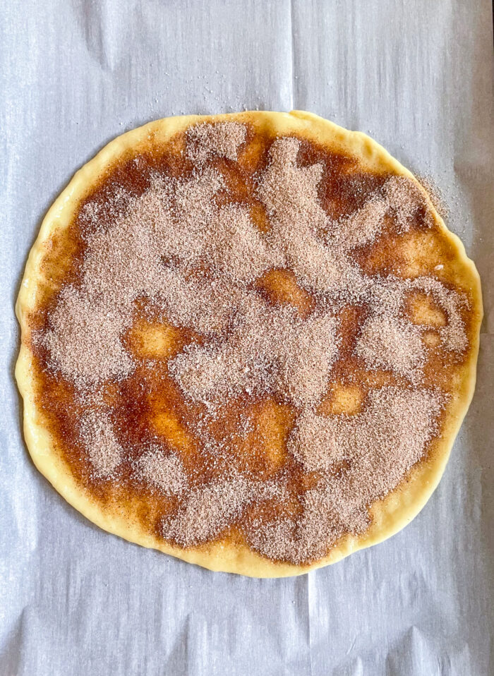 melted butter and cinnamon sugar spread over the dough circle