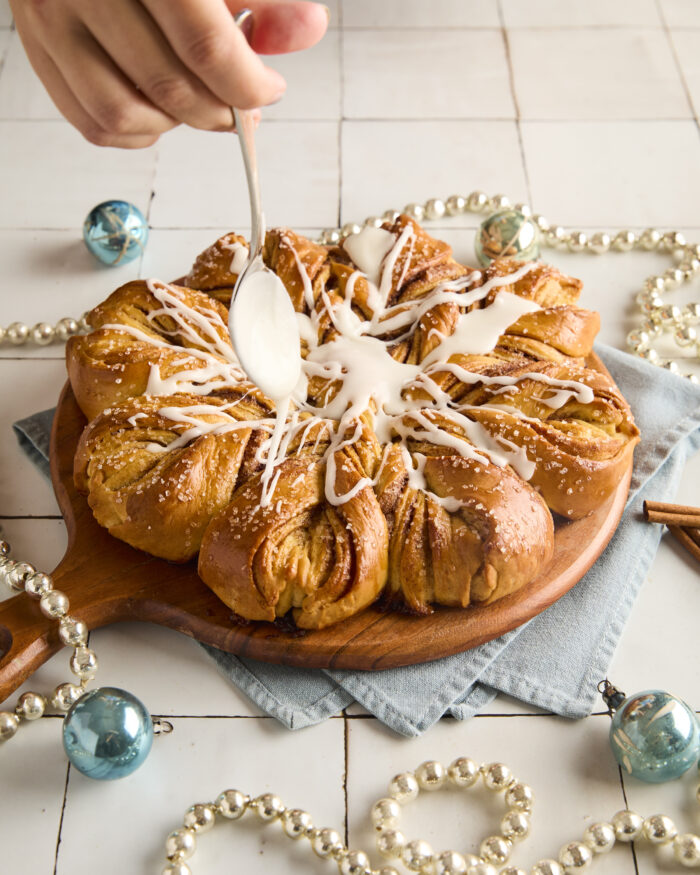 drizzling glaze over cooled snowflake bread