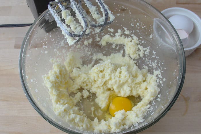 Eggs being added to butter and sugar mixture, one at a time