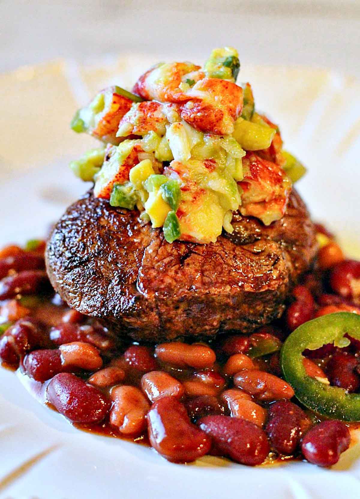 Pan seared filet mignon topped with lobster salsa and served over beans.