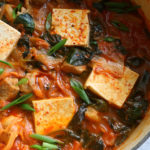 Kimchi Jjigae - spicy, savory classic Korean soup recipe made with tender pork shoulder and fermented kimchi. This easy soup has big flavor!