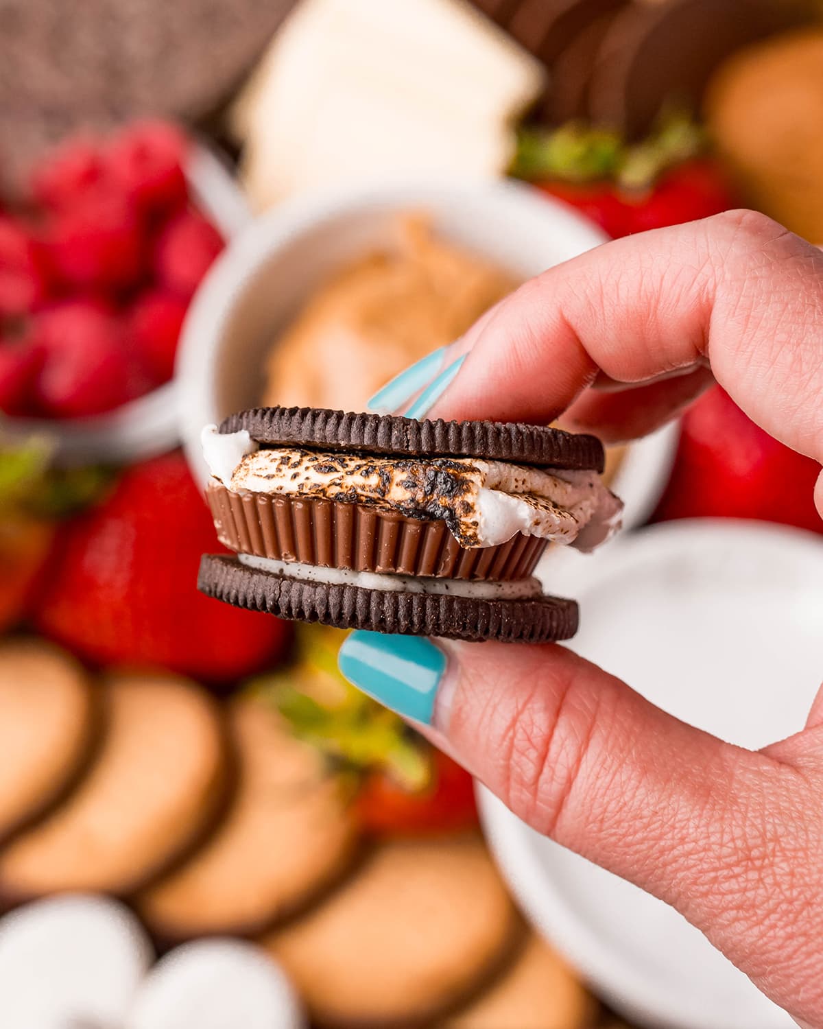 An Oreo s'more with a marshmallow and a reeses in the middle. 