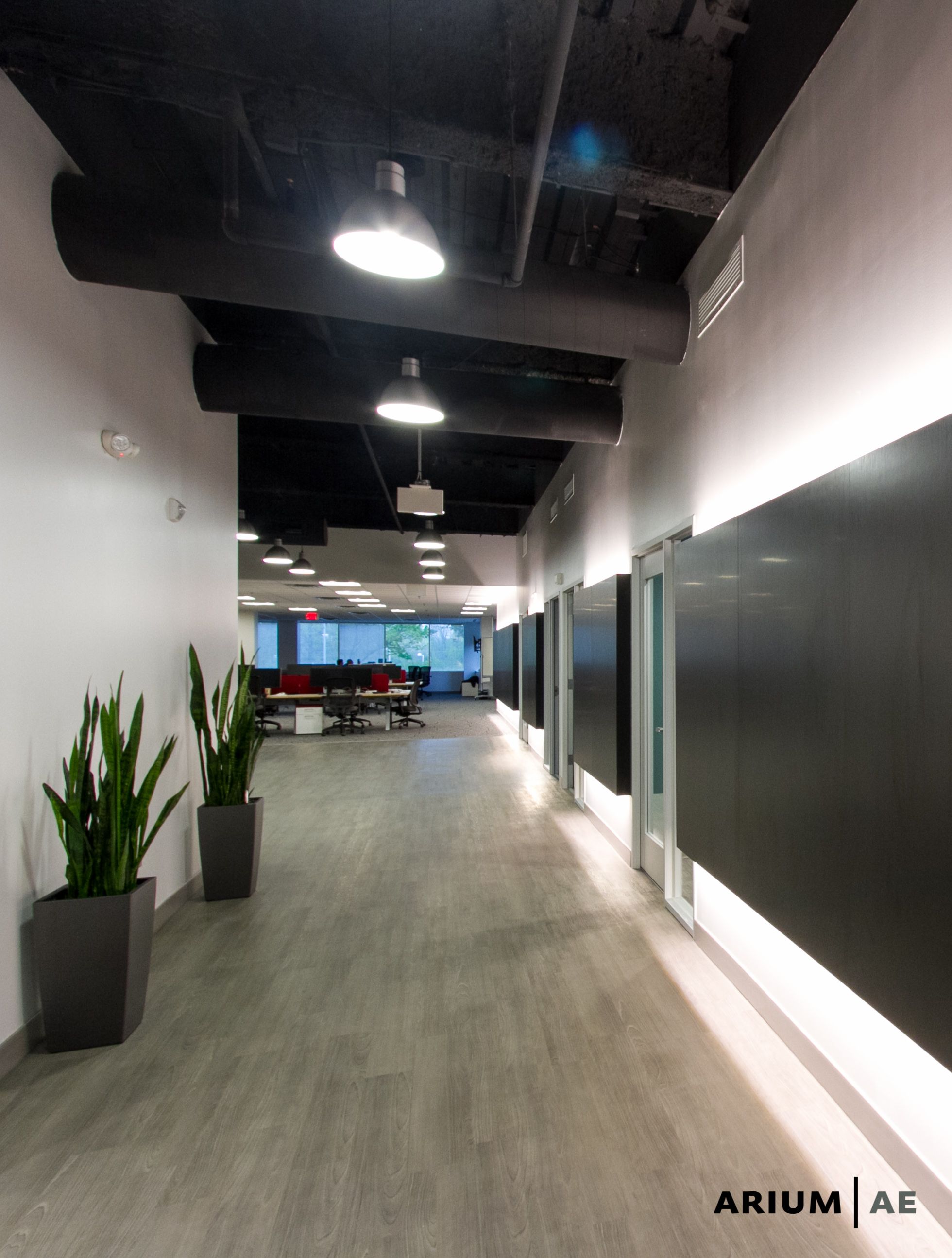 Corridor in an office space, with black laminate accent wall with light