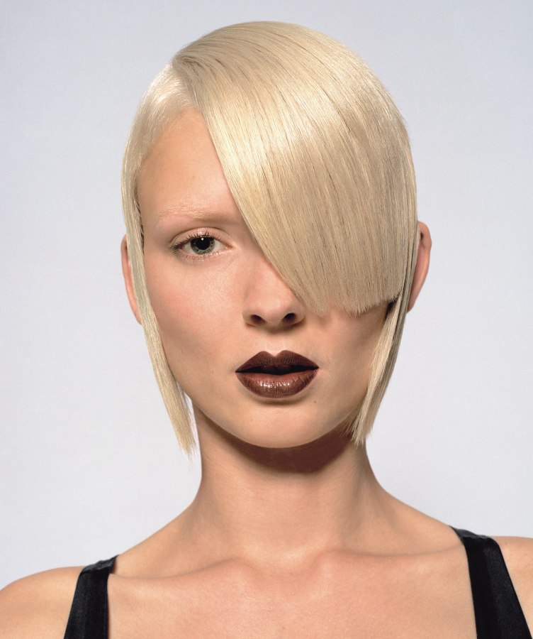 Neat and flat haircut based on a graphical shape with asymmetrical bangs