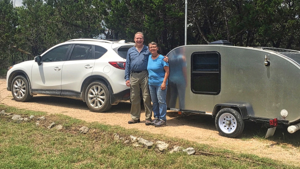 photo of Marilyn and Jim in front of a teardrop trailer