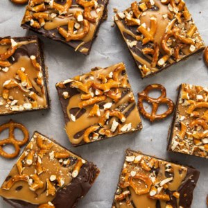 Cut up Salted Caramel Pretzel Brownies on parchment paper with pretzels from overhead.