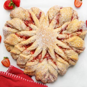 Strawberry Heart Bread on a white counter with strawberries and a red napkin.