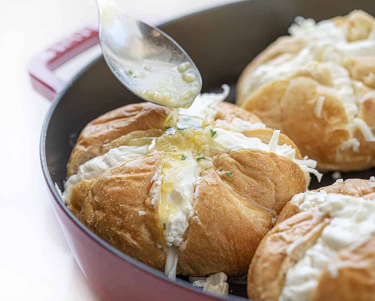 Cheesy Garlic Pull with Garlic Butter Being Drizzled over before Baking