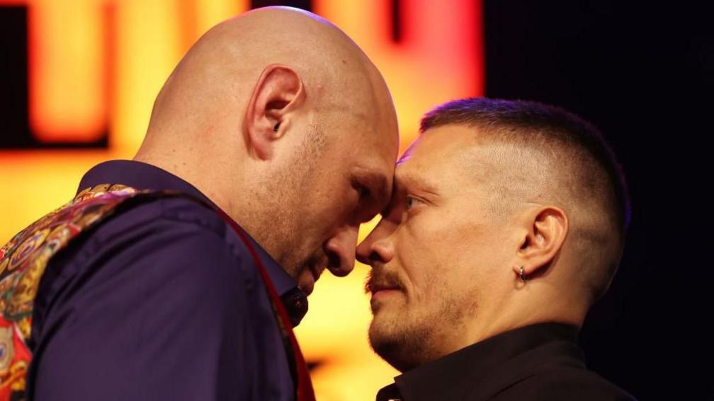 Tyson Fury touches his forehead against Oleksandr Usyk's during a face-off