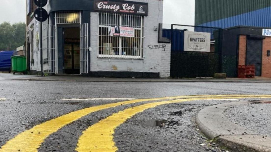 Double yellow lines on a road in front of a cafe