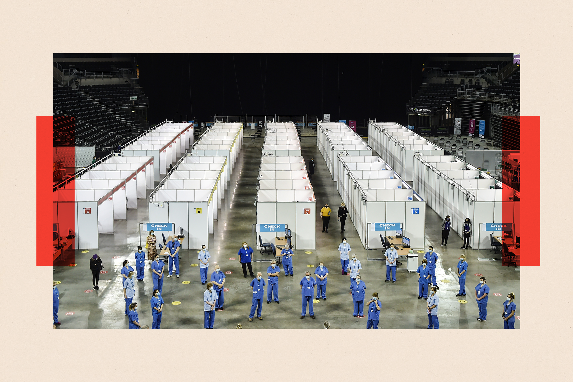 Vaccinators in blue uniforms are infront of rows of vaccine booths