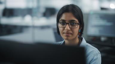 Call Center Office: Portrait of Friendy Indian Female IT Customer Support Specialist Working on Computer, Talking with Clients, Solving Problems, Finding Software Solutions, Helping to Choose Products 