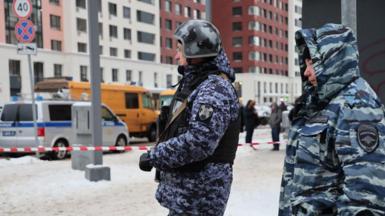 Police officers in camouflage outfits stand guard near a scene of an explosion in Moscow