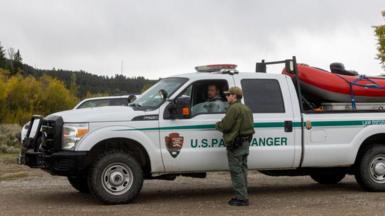 US park rangers talk at a truck 