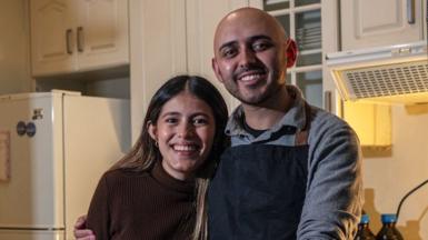 Fabriccio smiles at the camera while putting his arm around his wife, Lucia