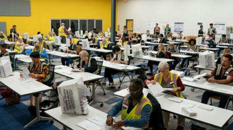 North Carolina election officials prepare absentee ballots for the 5 November election