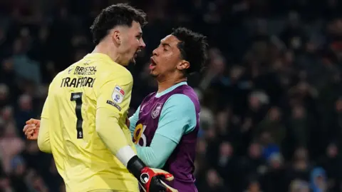 Burnley goalkeeper James Trafford celebrates with team-mate Bashir Humphreys after saving a penalty from Sunderland's Wilson Isidor