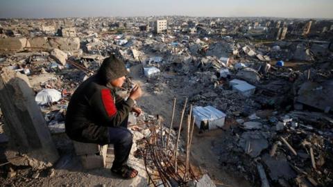 A Palestinian looks on as the rubble of destroyed buildings is seen at Jabalia refugee camp, northern Gaza Strip